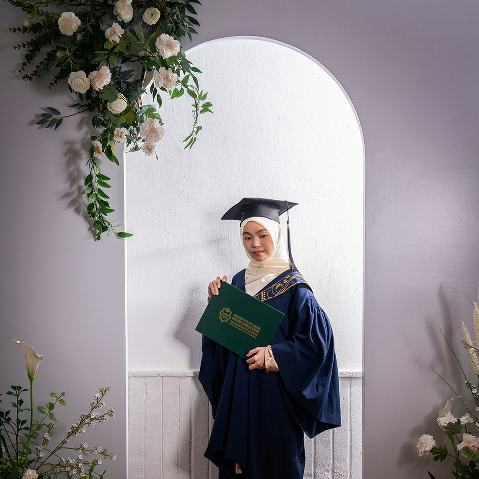 Graduate individual portrait with studio floral backdrop