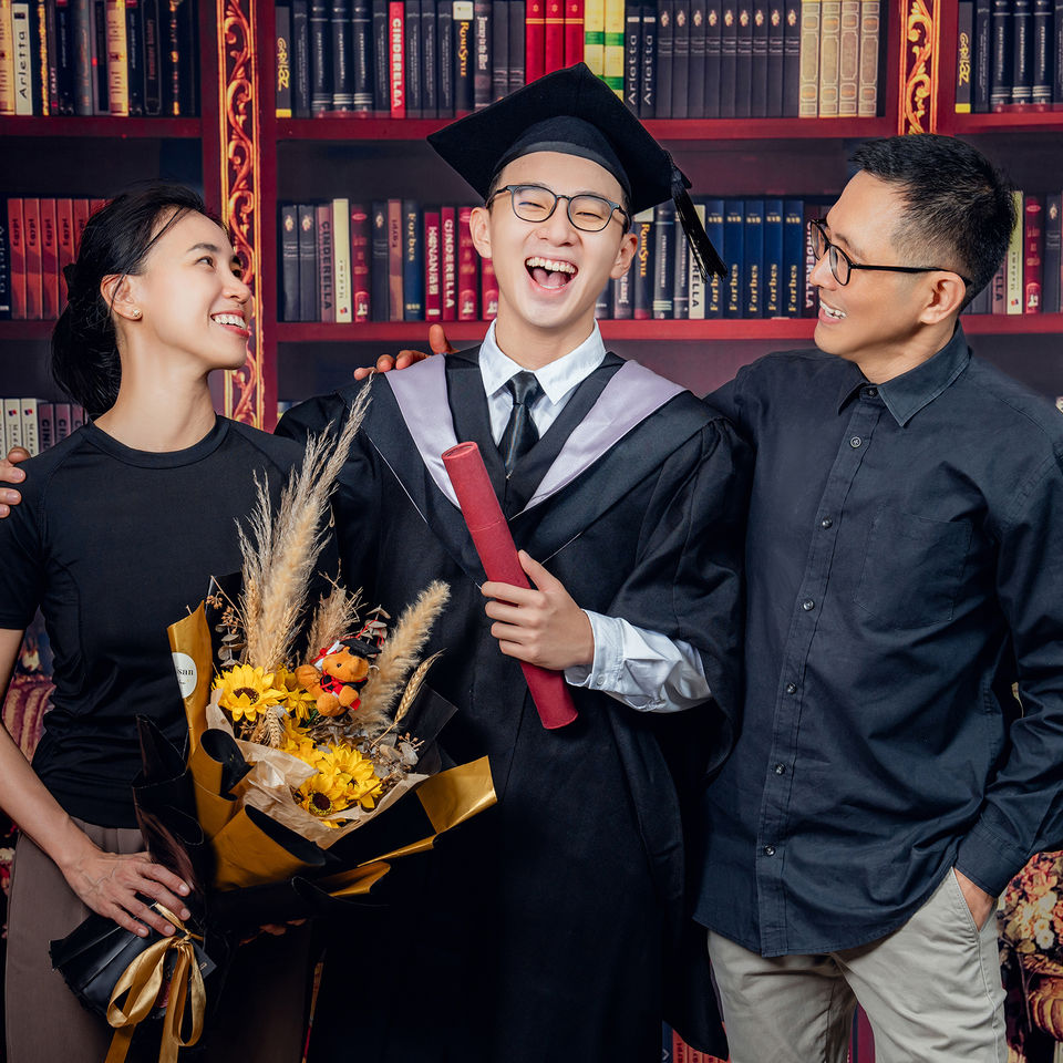Graduate with parents and bouquet in Kuantan studio